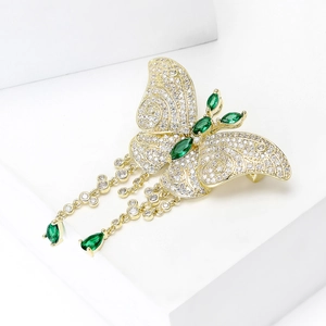 Détail d'une broche papillon avec zircons vert émeraude et pompons de cristal
