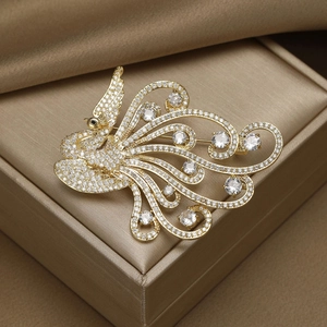 Close-up of a golden phoenix brooch with micro-pave zircons on a luxury silk background