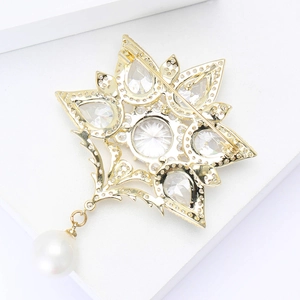 Vintage Blumenbrosche in Gold mit Zirkonia und Perle auf weißem minimalistischem Hintergrund