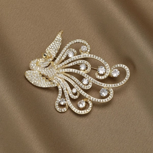 Luxury gold phoenix brooch featuring shimmering micro-pave zircons on a satin background