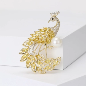 Luxury gold peacock brooch with yellow crystals and a large white pearl for suits