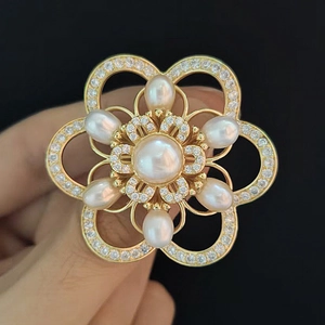 Detailed close-up of double-layer camellia brooch with pearls and sparkling crystals