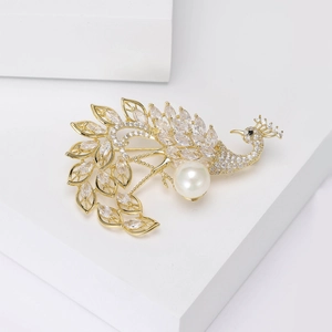 Detailed close-up of a luxury gold peacock brooch with sparkling zircons and a white pearl