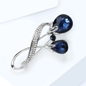 Détails d'une broche tulipe de luxe avec cristaux bleus en goutte et monture argentée