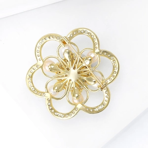 Back view of a gold hollow camellia brooch with pearls and detailed pin mechanism