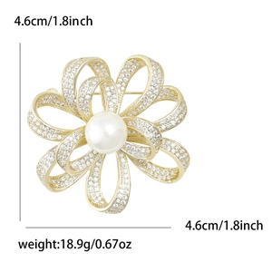 Luxuriöse goldene Blumenbrosche mit funkelnden Kristallen und einer großen weißen Perle