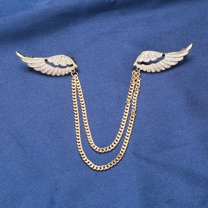 Vue détaillée des broches ailes d'ange dorées avec zircons sertis et doubles chaînettes
