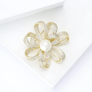 Eleganter goldener Schleifenbrosche mit Zirkonia-Besatz und zentraler weißer Perle