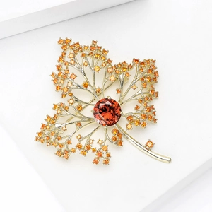 Luxurious maple leaf brooch with red and orange zircon stones in gold plating