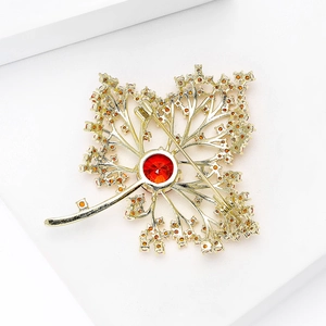 Back view of luxury maple leaf brooch with red gemstone and amber rhinestones