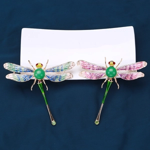 Elegant dragonfly brooches with gradient enamel wings and gemstones on blue fabric