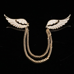 Détail de broches ailes d'ange dorées avec pavage de micro-zirconiums et chaînes élégantes
