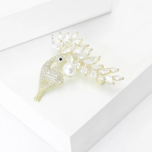 Eleganter goldener Pfau-Brosche mit Kristall-Zirkonia-Flügeln und weißer Perle auf Sockel