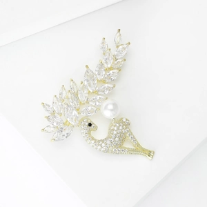 Eleganter Schwan-Brosche in Gold mit Zirkon-Besatz und Perle auf weißem Treppen-Dekor