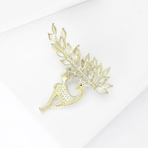 Exquisite goldene Vogel-Brosche mit Perle und funkelnden Kristallen auf weißem Sockel