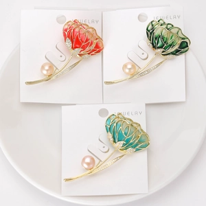 Detailed view of luxury enamel hibiscus brooches with pearls and crystals in three colors