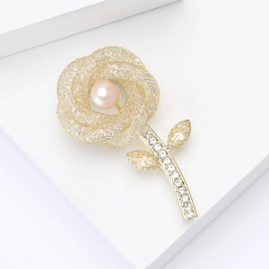 Élégante broche rose en maille dorée avec perle rose et incrustation de cristaux zircons