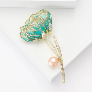 Macro detail of luxury flower brooch featuring green enamel petals and inlaid cubic zirconia