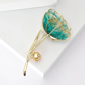 Luxurious gold flower brooch with green enamel petals and a pink pearl accent