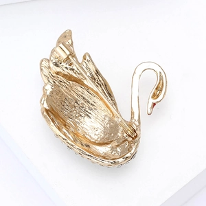 Detail view of the golden swan brooch back showing the secure safety pin fastening system