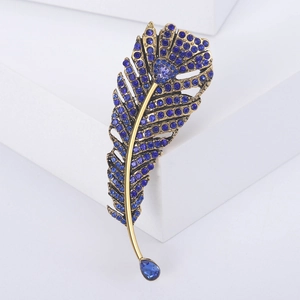 Vintage gold feather brooch with navy blue crystals and a teardrop gemstone