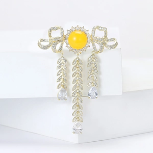 Elegant gold bow brooch with yellow center stone and leaf tassel charms for women