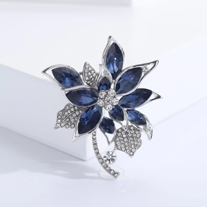 Broche fleur argentée élégante avec pierres précieuses bleu foncé et cristaux blancs brillants