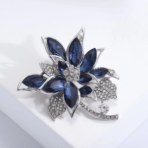 Détail de la broche fleur avec cristaux marquise bleus et strass sur feuilles argentées