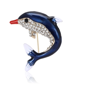 Broche dauphin en émail bleu avec cristaux blancs sur base dorée et reflet élégant