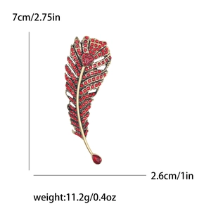 Elegant gold feather brooch with red rhinestones, measures 7cm x 2.6cm and weighs 11.2g