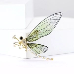 Macro shot of dragonfly brooch showing detailed green wings and sparkling cubic zirconia