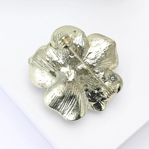 Broche camélia dorée élégante pour femme avec une vue arrière de l'épingle de sécurité