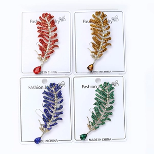 Detailed macro view of four multicolored rhinestone feather brooches with crystal drops