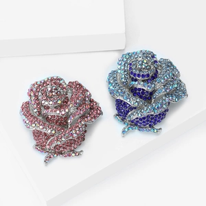Broches roses exquises en alliage avec strass bleus et roses sur un fond blanc épuré