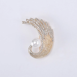 Détail d'une broche phoenix dorée de luxe avec strass scintillants et une grande perle