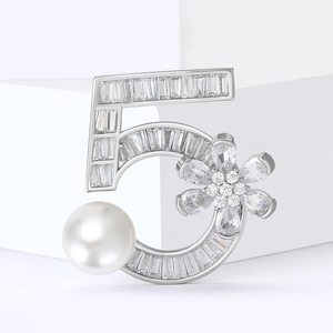 Élégante broche argentée sertie de zircons, design numéro 5 et détail de perle blanche
