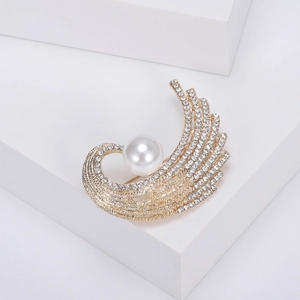 Broche luxueuse en forme de plume avec strass et perle sur support d'exposition