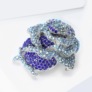 Gros plan d'une broche rose en cristal bleu avec strass brillants et base en alliage argenté