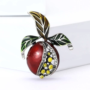 Broche grenade raffinée avec graines en émail rouge et feuilles vertes sur blanc