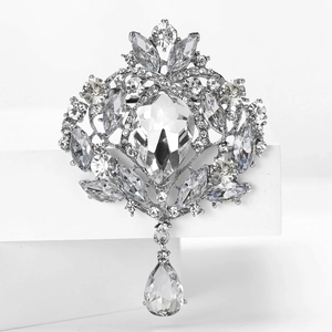 Détail macro de broche vintage en cristal argenté avec pendentif sur bloc blanc
