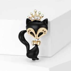 Eleganter schwarzer Fuchsanstecker mit goldener Krone und Kristallakzenten auf Podest