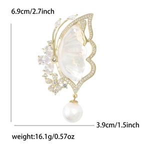 Luxury butterfly brooch in gold with white shell inlay, cubic zirconia, and pearl drop