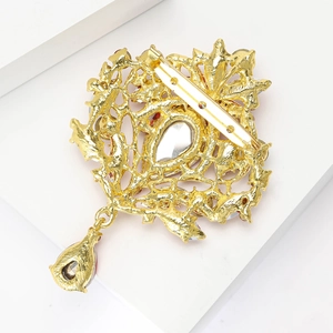 Vue détaillée du dos d'une grande broche en alliage doré avec des motifs ajourés complexes