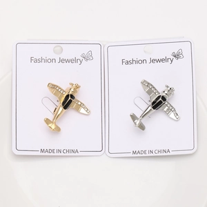Detailed view of gold and silver airplane brooches with sparkling rhinestone wings