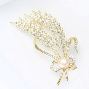 Broche épi de blé dorée sertie de cristaux brillants et d'une perle rose centrale élégante