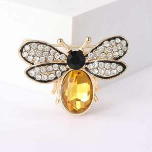Detailed macro view showing the gold metal bee brooch with sparkling wings and yellow gem