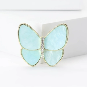 Détail de la broche papillon avec ailes bleues texture nacre et corps orné de cristaux