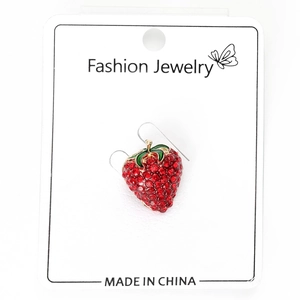 Détail d'une boucle d'oreille fraise rouge avec cristaux et feuilles en émail vert