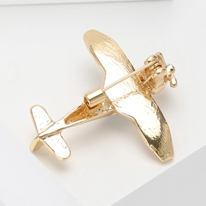 Minimalist gold alloy airplane brooch showing high-quality metal texture and pin detail