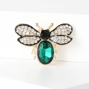 Macro shot of bee brooch with green crystal body and sparkling rhinestone wings